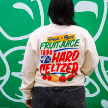 Load image into Gallery viewer, Person wearing a sweatshirt with colorful text and graphics on the back, standing against a green wall with white abstract designs.