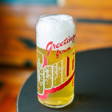 Load image into Gallery viewer, A tall can shaped glass full of light beer with &quot;Greetings from Boulevard&quot; printed on it like a vintage postcard
