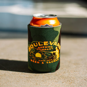 A camo drink koolie depicting a fisherman, that says, "Boulevard Brewing Company, Since 1989, Beer & Tackle".