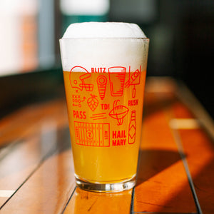A pint glass full of light beer with red football and beer icons