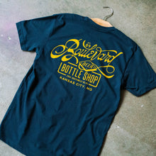 Load image into Gallery viewer, The back of a navy t-shirt with yellow lettering.

