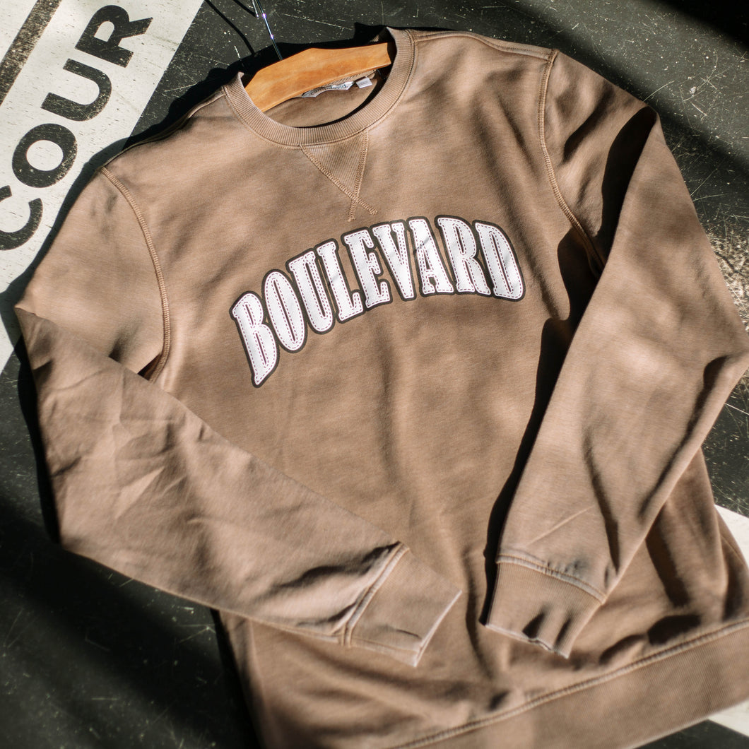 A brown crewneck with faux-embroidered white lettering.