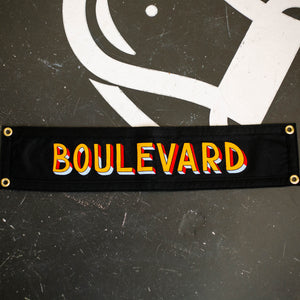 A black rectangular pennant that says, "BOULEVARD", in colorful lettering.