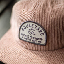 Load image into Gallery viewer, A close-up of the arch patch on a pink corduroy cap.
