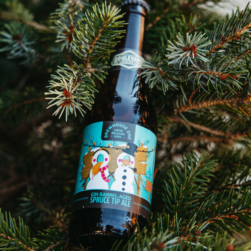 A bottle of Gin-Barrel Aged Spruce Tip Ale, resting in a Christmas Tree.