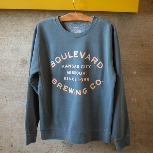 A slate blue crewneck with the words, 