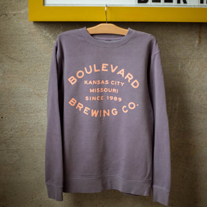 A plum crewneck with the words, "Boulevard Brewing Co. Kansas City, Missouri, Since 1989" in pink lettering.