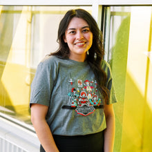 Load image into Gallery viewer, Person wearing a t-shirt with a colorful Space Camper graphic design in front of a window.
