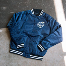 Load image into Gallery viewer, Blue jacket with white and black accents on a textured surface
