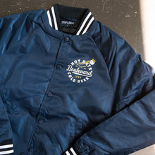 Load image into Gallery viewer, Navy blue jacket with white text and branding on a textured surface
