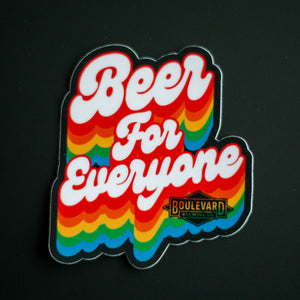 A rainbow sticker that says, "Beer for Everyone" against a black background.