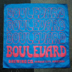 A blue bandana with pink repeated lettering.