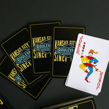 Load image into Gallery viewer, A spread of black paying cards and a face up Joker card.
