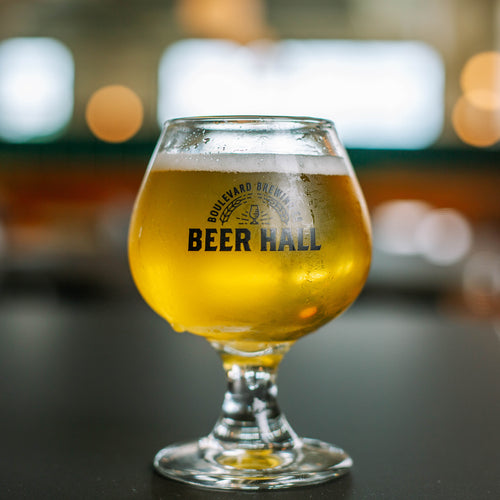 A short tasting glass full of beer featuring the Boulevard Beer Hall logo