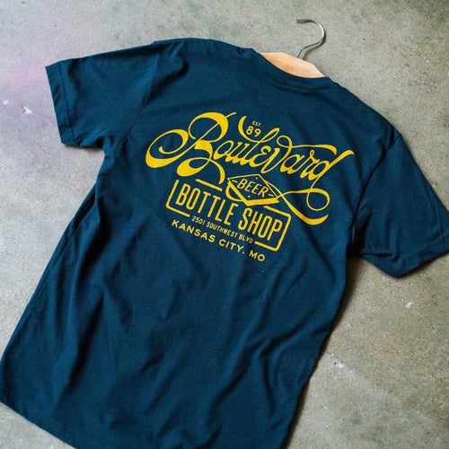 The back of a navy t-shirt with yellow lettering.