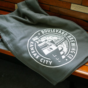 folded hunter green blanket with "BOULEVARD BREWING CO KANSAS CITY" and brewery image in white ink