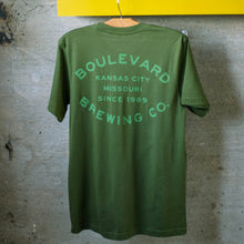 Load image into Gallery viewer, The back of the olive barrel stamp tee
