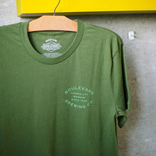 Load image into Gallery viewer, The front of the olive barrel stamp tee
