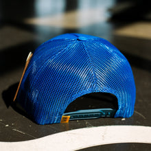 Load image into Gallery viewer, Blue mesh cap on a reflective surface with a blurred background

