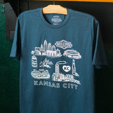 Load image into Gallery viewer, Blue t-shirt with white graphics and text on a hanger against a dark background

