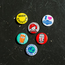 Load image into Gallery viewer, Set of colorful buttons on a black textured surface
