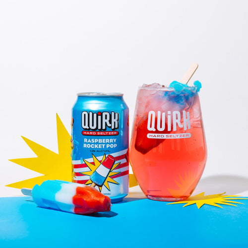 Quirk hard seltzer can and glass with a red and blue drink on a white background