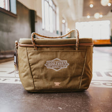 Load image into Gallery viewer, A green cooler with rope handles and a white embroidered Boulevard diamond logo.
