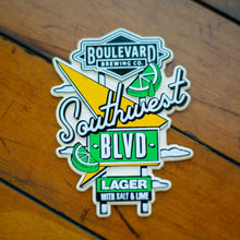 Load image into Gallery viewer, A green, black, and white die-cut magnet depicting a Southwest Boulevard Lager sign.
