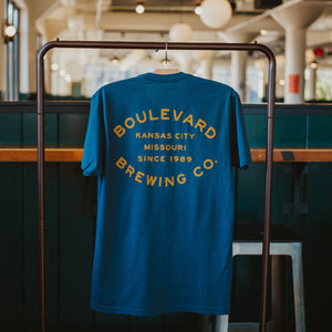 The back of an indigo t-shirt with gold lettering that says, "Boulevard Brewing Co., Kansas City, Missouri, since 1989".