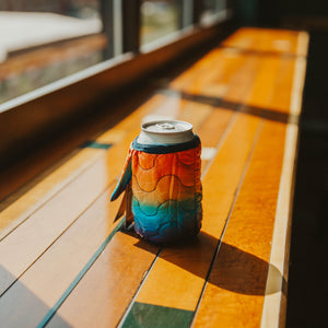 One beer can inside of one colorful beer blanket.