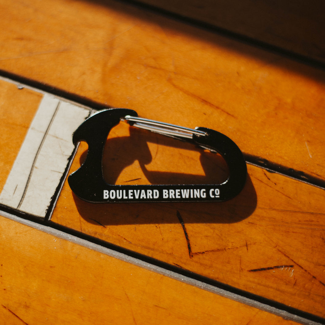A black metal carabiner that is also a bottle opener