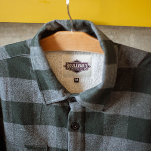 A close up view of the inside tag of the Boulevard Sherpa Jacket, featuring a Boulevard Diamond logo.