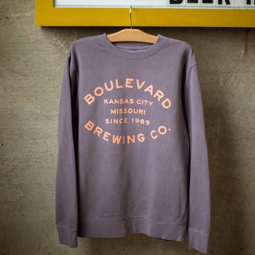 A plum crewneck with the words, 