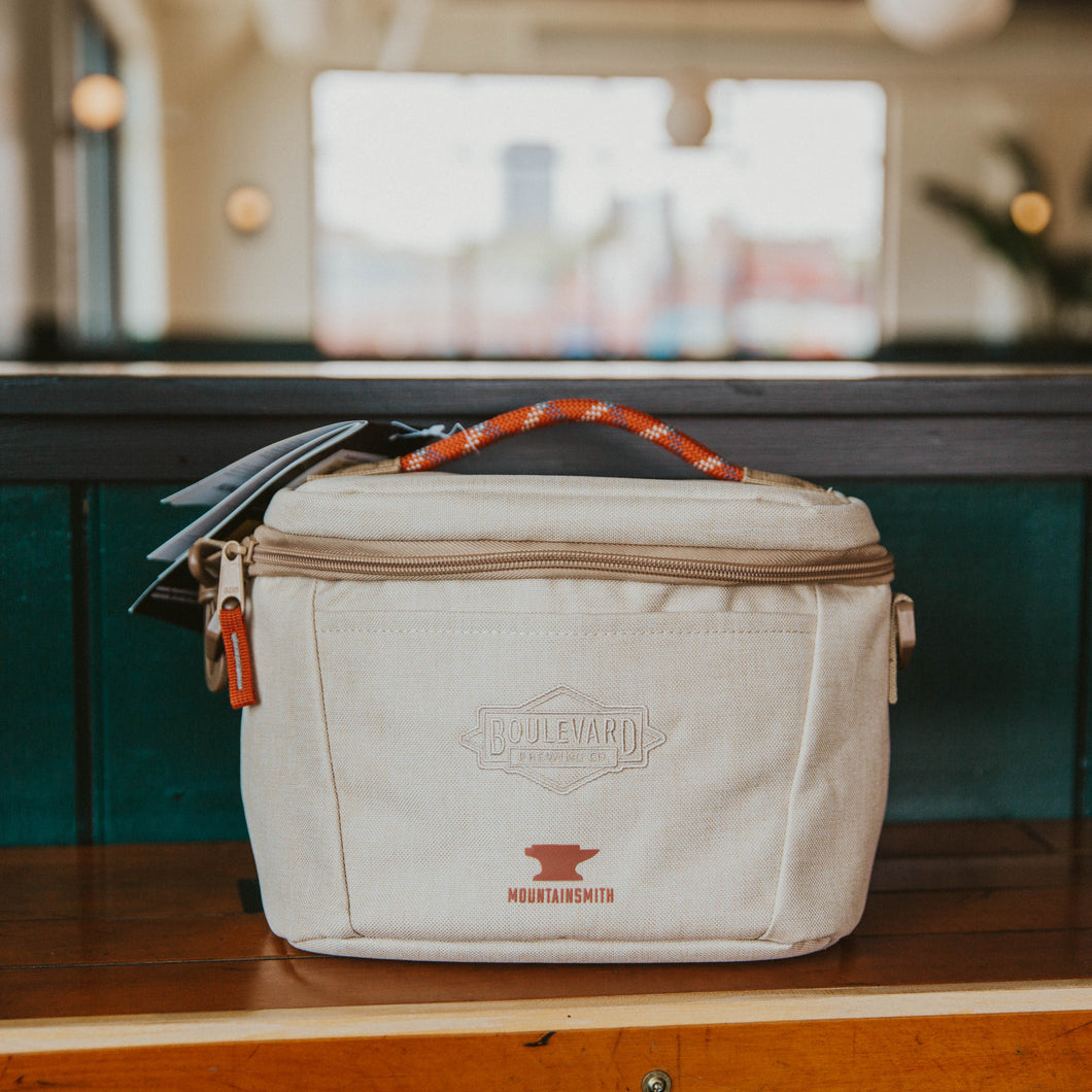 A tan Boulevard Takeout Cooler with an orange rope handle.